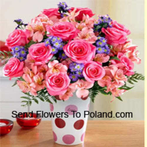 Розовые розы, розовые орхидеи и разноцветные фиолетовые цветы красиво организованы в стеклянной вазе